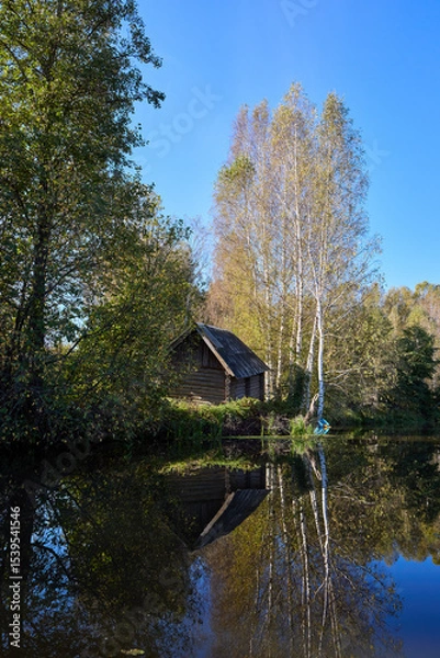 Obraz Tranquil Reflections: House and Trees Mirrored in River