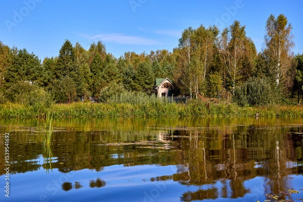 Obraz Tranquil Reflections: House and Trees Mirrored in River