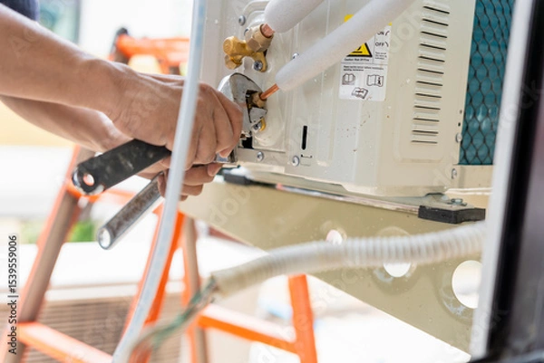 Obraz Close Up of Technician Installation Outdoor Air Conditioning Unit with Wrench, Repairman fix air conditioning systems, Male technician service for repair and maintenance of air conditioners