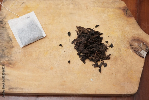 Obraz Tea bags and a bunch of loose tea in the wooden board. A quick and convenient way to brew tea.
