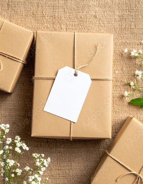 Obraz Kraft Paper Gift Box with Blank Label on Burlap Background.photo, commercial, eco, elegant, graphic, image, label, marketing, minimal, present, ribbon, sustainable, warm, branding,