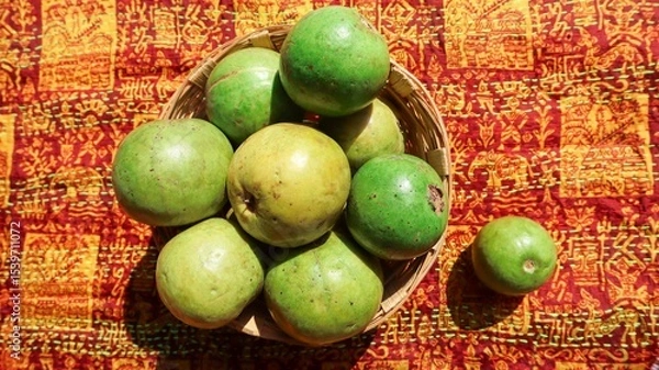 Fototapeta Top view of Fresh ripe guavas stacked in wicker basket with designer pattern background. These jaam phal guava fruits are red inside