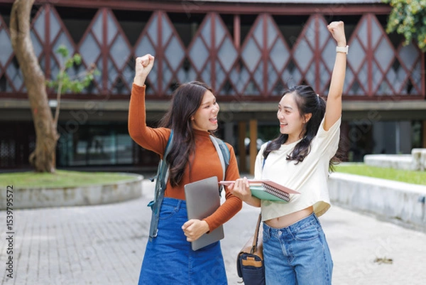 Fototapeta Two happy students celebrating success on campus