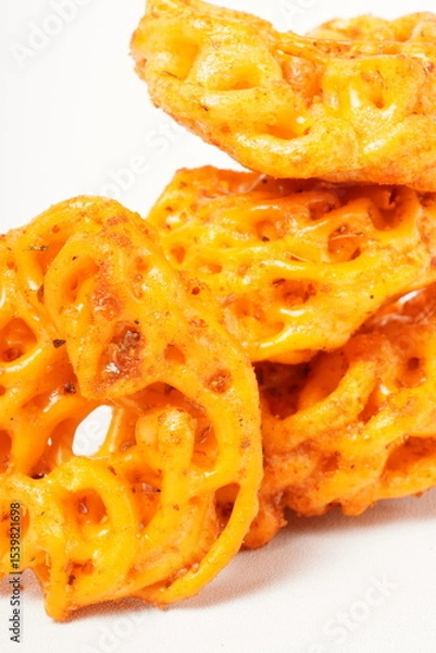 Fototapeta A pile of spicy Indonesian crackers or Kerupuk with spiral twists, coated in red-orange chili powder and rich spices. Bold, flavorful, and appetite-boosting. Photographed against a white background.