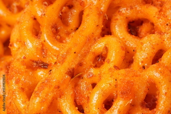 Fototapeta A pile of spicy Indonesian crackers or Kerupuk with spiral twists, coated in red-orange chili powder and rich spices. Bold, flavorful, and appetite-boosting. Photographed against a white background.