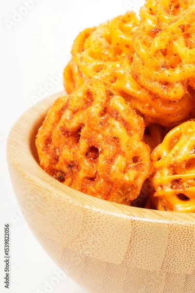 Fototapeta A pile of spicy Indonesian crackers or Kerupuk with spiral twists, coated in red-orange chili powder and rich spices. Bold, flavorful, and appetite-boosting. Photographed against a white background.