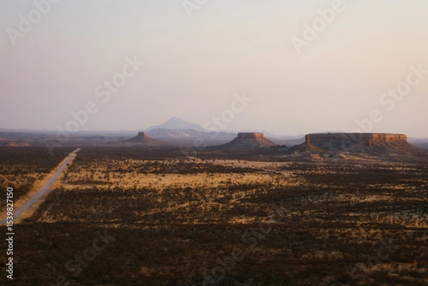 Obraz Vast desert plain in Ugab, Namibia, with striking mesa formations reminiscent of the American West under soft dusk light.