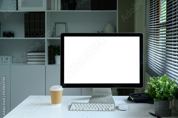Fototapeta Modern desktop computer with blank screen on white desk in stylish home office