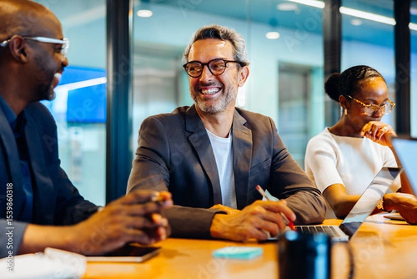 Fototapeta Business professionals talking and smiling during a meeting in a conference room