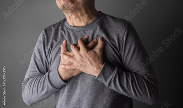 Fototapeta heart disease concept. asia old man pressing on chest with painful expression. severe heartache and having heart attack or painful cramps.