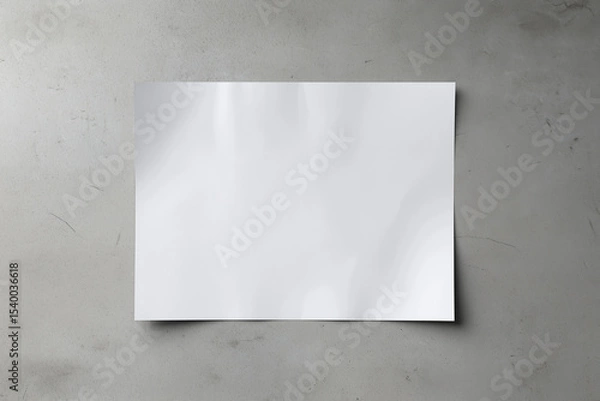Fototapeta A white A1 size poster mockup on a on a raw concrete background with soft shadows