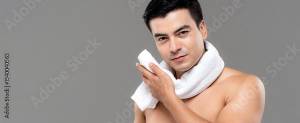 Fototapeta Shirtless man drying face with white towel after workout on gray banner background, men skin care and beauty concept