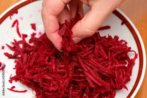 Obraz Grating vibrant beets in a rustic kitchen for healthy dishes