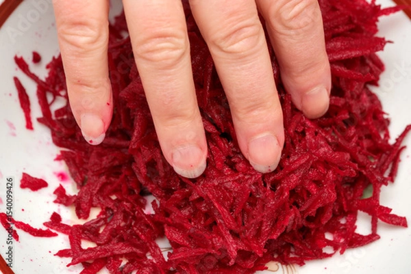 Obraz Shredding vibrant beets in a rustic kitchen at midday