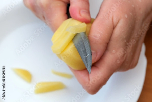 Obraz Mastering the art of peeling fresh potatoes in a cozy kitchen