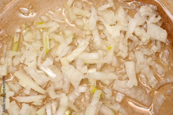 Obraz Chopped onions sizzling in a warmpan, creating a savory aroma