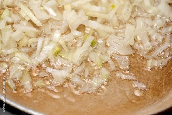 Obraz Sizzling onions create an aromatic base in a warm kitchen