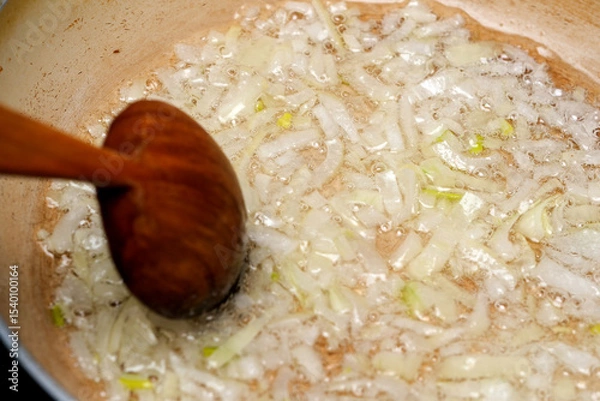 Obraz Sizzling onions caramelizing in a pan during a home-cooked meal