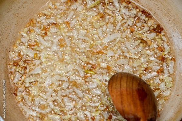Obraz Sizzling onions caramelizing in a pot on a cozy kitchen stove