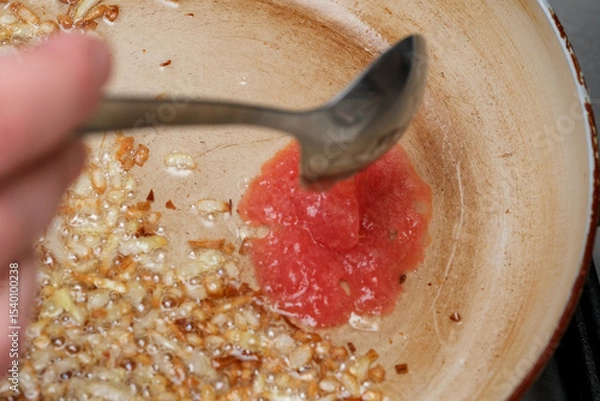 Obraz Cooking a flavorful sauce with sautéed onions and fresh tomatoes