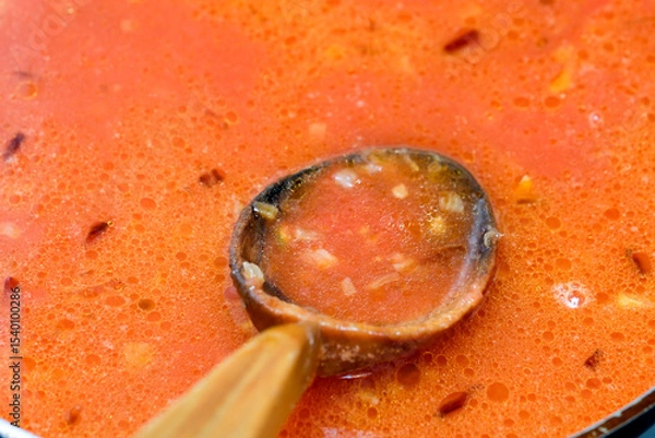 Obraz Savory soup simmers in a large pot on a cozy kitchen stove