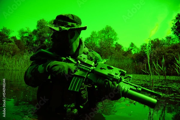 Obraz Soldier in camouflage with a rifle crouches in water surrounded by dense vegetation, wearing a hat and gloves, during low-light conditions.