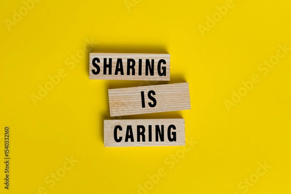 Fototapeta sharing is caring words text on wooden blocks isolated on yellow background