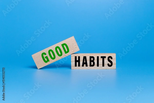 Fototapeta good habits words symbol on wooden blocks isolated on white ang green background. motivational words concept