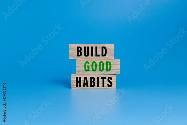 Fototapeta build good habits words symbol on wooden blocks isolated on white ang green background. motivational words concept