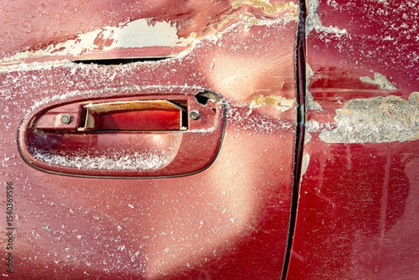 Fototapeta The rear door of the red car has a dent, indicating a strong impact. The paint on the door is also damaged.