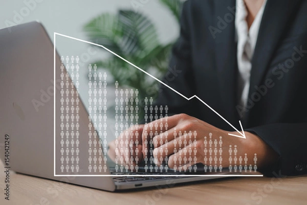 Fototapeta Businessperson working on laptop with a decreasing trend graph representing employment statistics or economic downturn.