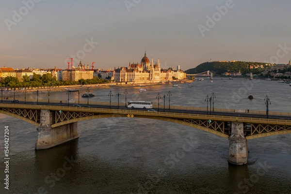 Fototapeta Scenic view of the famous Margit bridge acrossing over Danube river. Hungarian Parliament amazing building visible too in the photo
