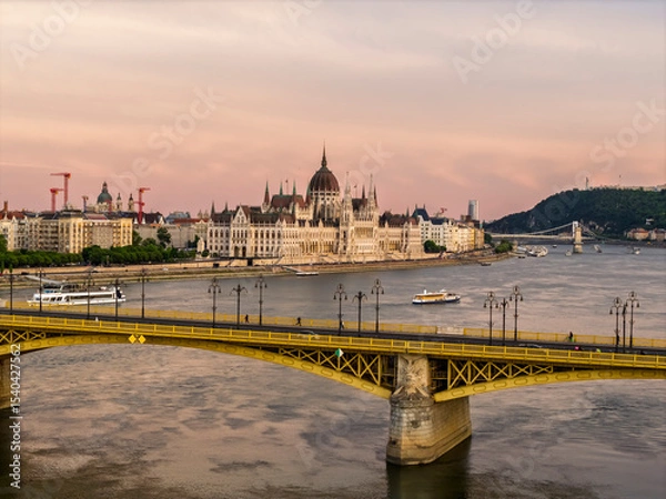 Fototapeta Scenic view of the famous Margit bridge acrossing over Danube river. Hungarian Parliament amazing building visible too in the photo
