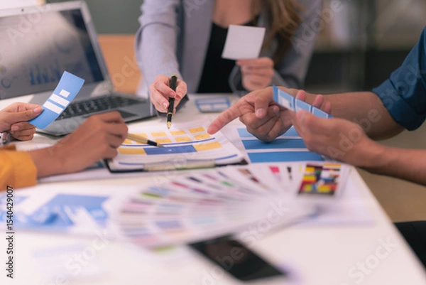 Fototapeta A design team focused on analyzing interface layouts and brainstorming to improve the user experience in a mobile responsive workshop with UI/UX Front End Designer Previewing.