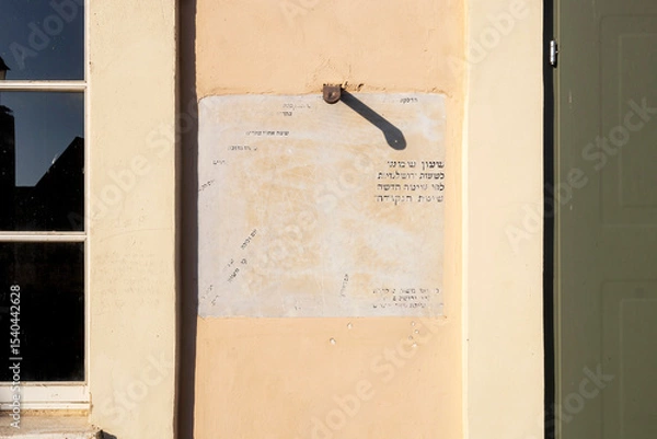Fototapeta A Wall sundial With Hebrew Text And A Shadow From A Hook.