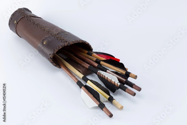 Obraz Different kinds of medieval handmade arrows with natural feathers in a handcrafted leather quiver isolated on white background