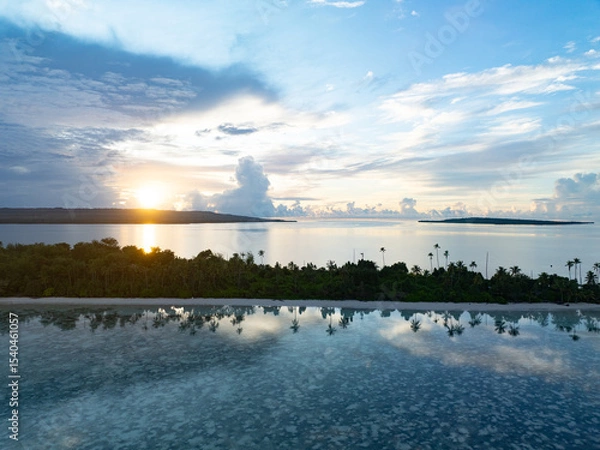 Obraz A serene sunrise silhouettes an island within Wakatobi National Park, off the coast of Sulawesi. This area is a popular destination for divers and snorkelers due to its high marine biodiversity.