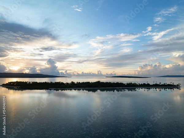 Obraz A serene sunrise silhouettes an island within Wakatobi National Park, off the coast of Sulawesi. This area is a popular destination for divers and snorkelers due to its high marine biodiversity.
