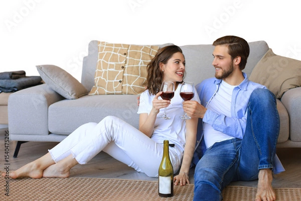Fototapeta Happy couple sitting, relaxing on floor, drinking red wine. Smiling young husband and wife rest enjoy romantic date on family weekend together on a transparent background