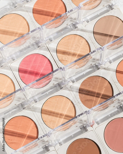 Fototapeta Repeating set of blush and highlighter pressed makeup powder with sunlight reflections and shadow
