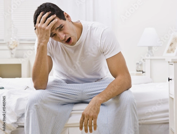 Obraz Attractive Man Sitting on His Bed and Yawning