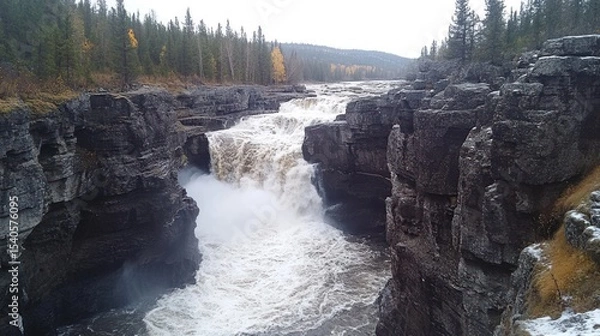 Fototapeta Powerful Waterfall Cascading Through Rocky Canyon