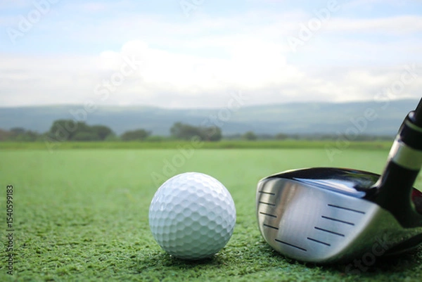 Fototapeta Golf Ball and Driver Club on Green Course Under Clear Sky