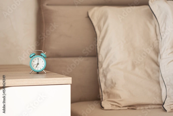 Obraz Retro turquoise alarm clock on a bedside table.