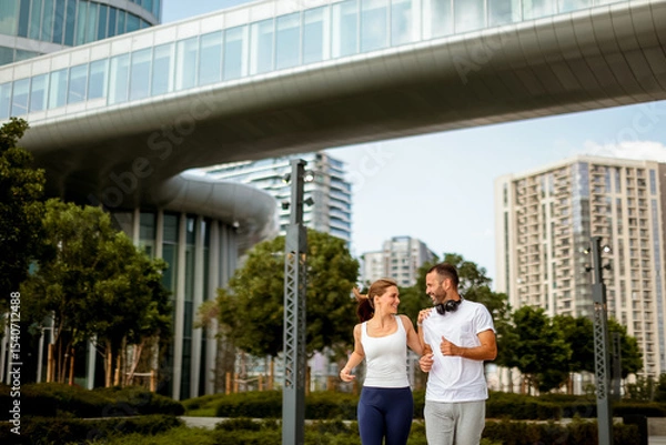 Obraz Joyful morning jog at a modern urban park surrounded by sleek skyscrapers and greenery