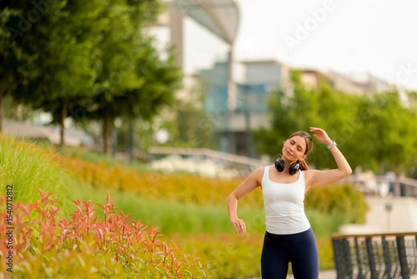 Obraz Woman enjoying music and movement in a vibrant urban park during a sunny afternoon