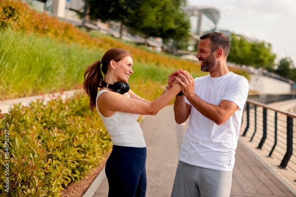 Obraz Couple enjoys a joyful moment while exercising together in a scenic park during a sunny afternoon