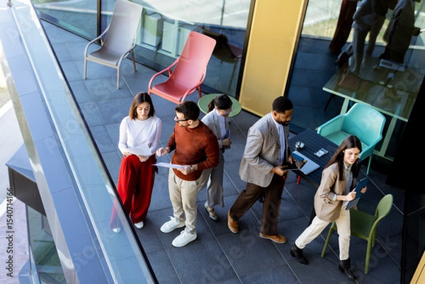 Obraz Team brainstorming and collaboration on a terrace during a sunny afternoon in a modern setting