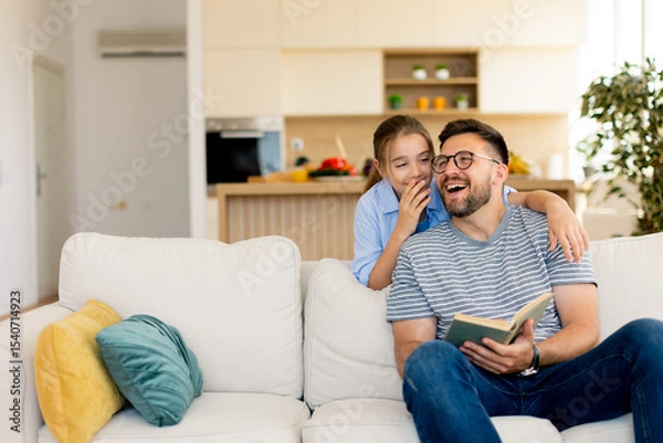Obraz Joyful moments of laughter and storytelling between a father and daughter in a cozy living room
