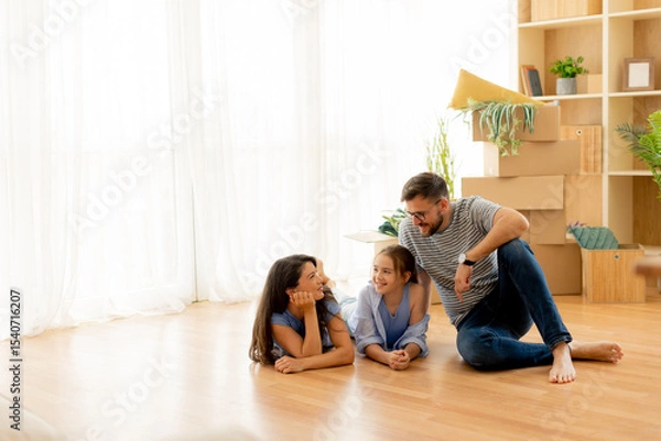 Obraz Family enjoys a cozy afternoon together in a sunlit living room filled with greenery and warmth